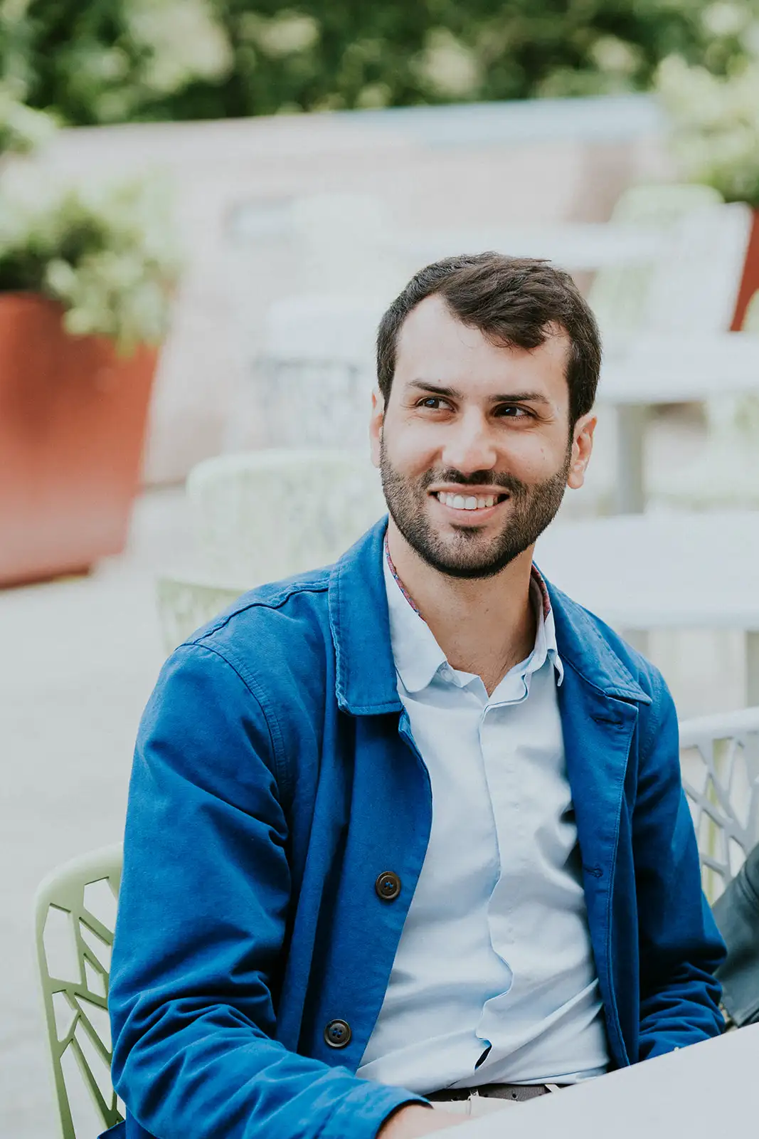 Pierre Scheibling, souriant, en veste bleue à une terrasse